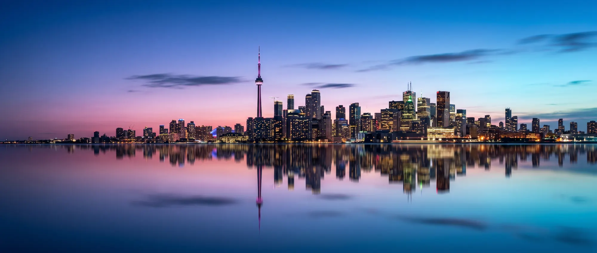 Toronto skyline with the CN Tower at blue hour, reflected in still water